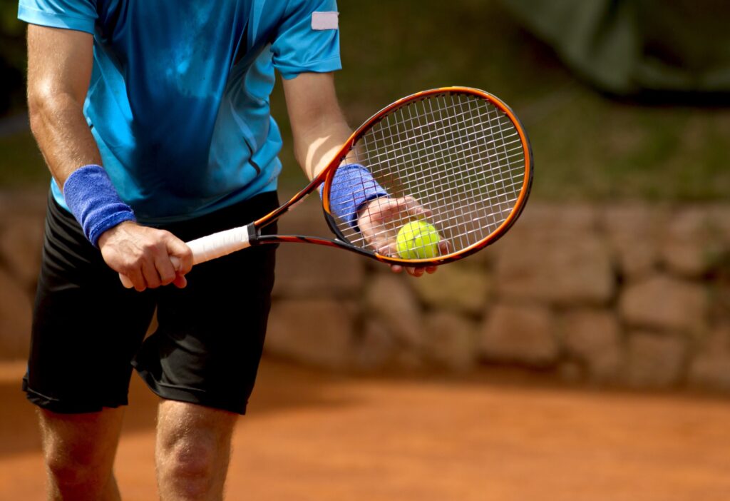 A tennis player prepares to serve a tennis ball during a match