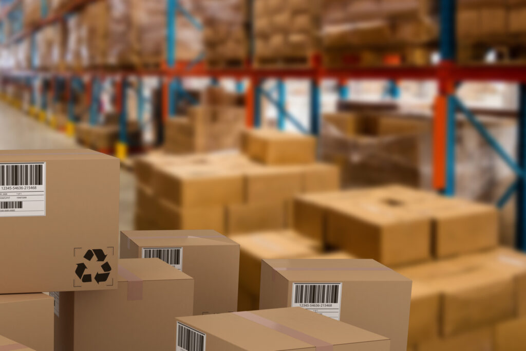 Group of composite cardboard boxes against boxes on pallet by rack